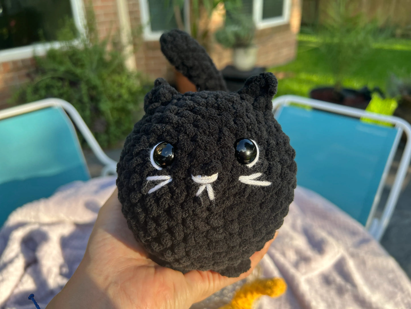 Front view of the black loaf cat plushie