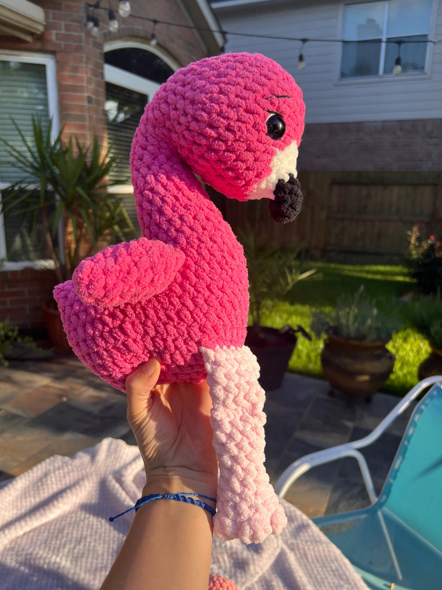 Side profile view of the hot pink flamingo plushie