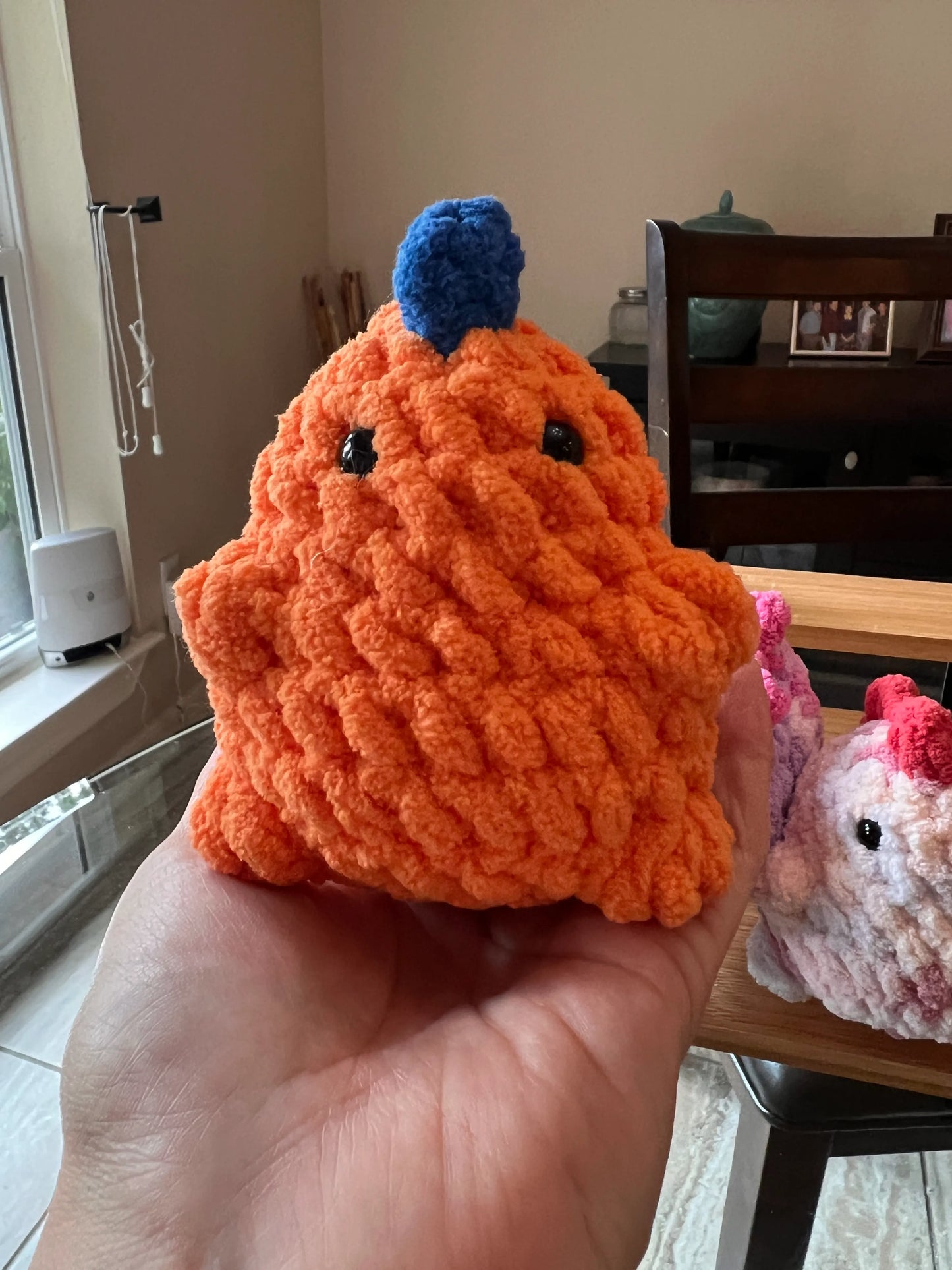 Front view of the orange dinosaur plushie