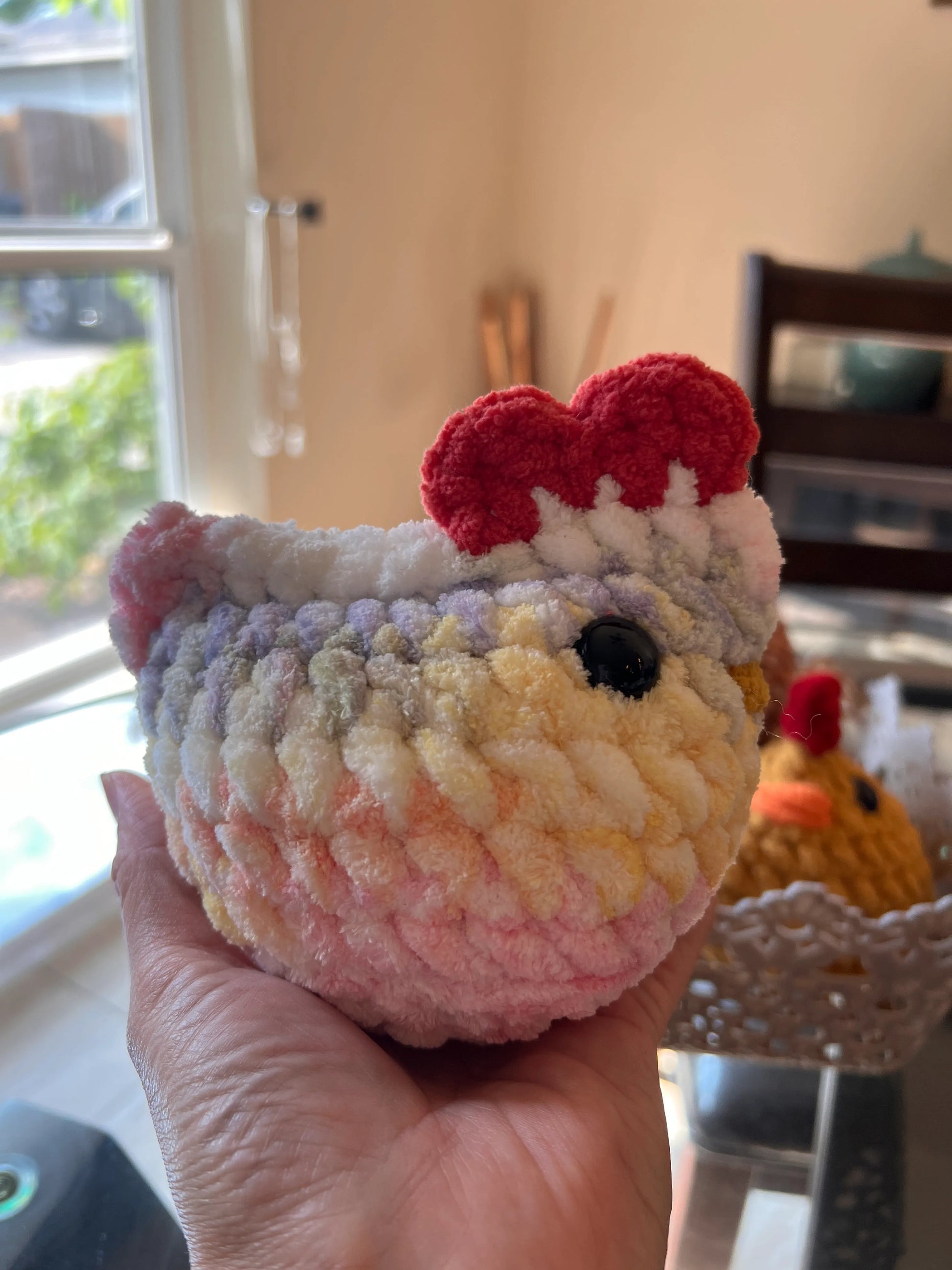 Side profile view of a pastel mix chicken plushie