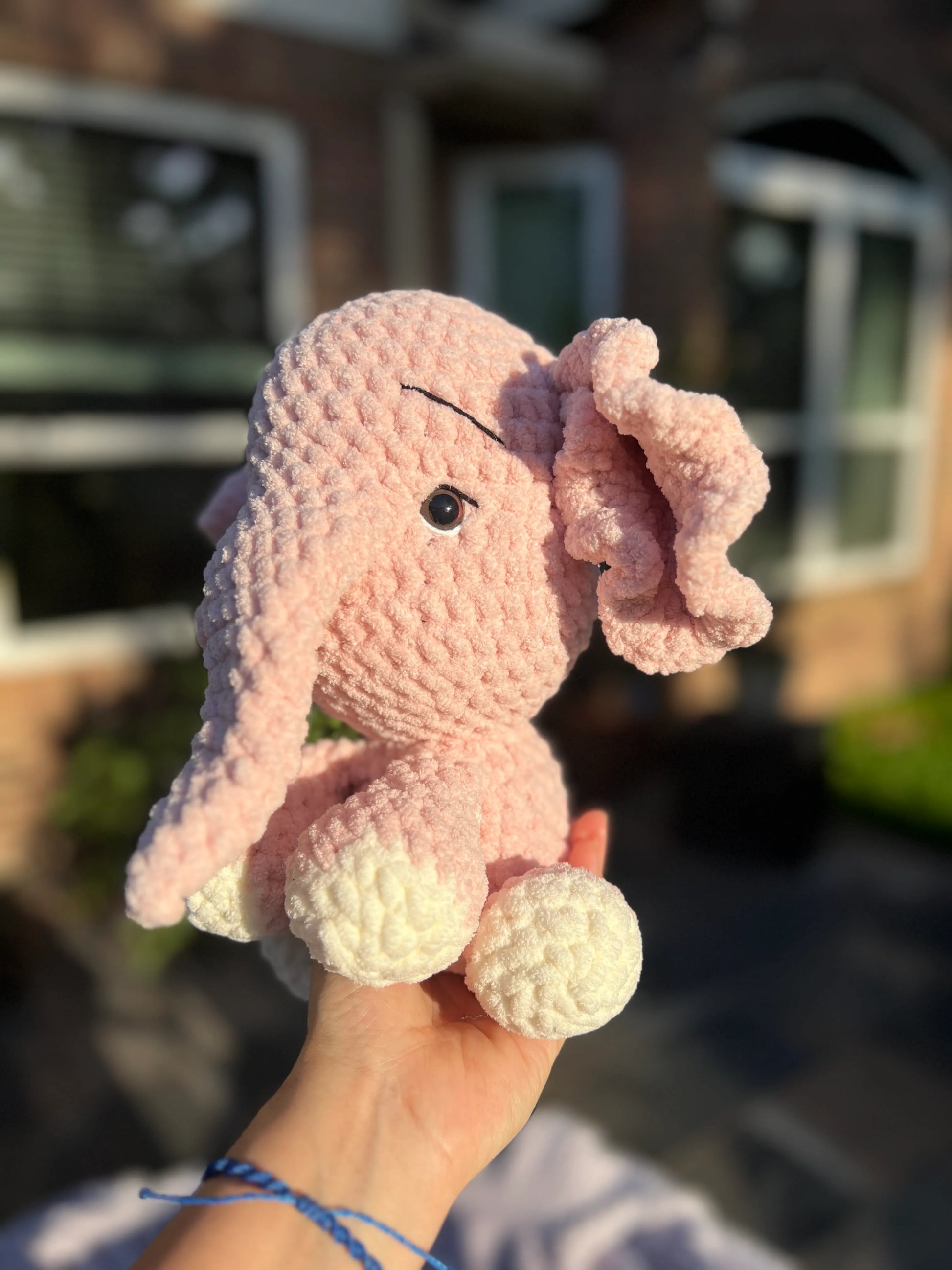 Side profile view of the pink elephant plushie 