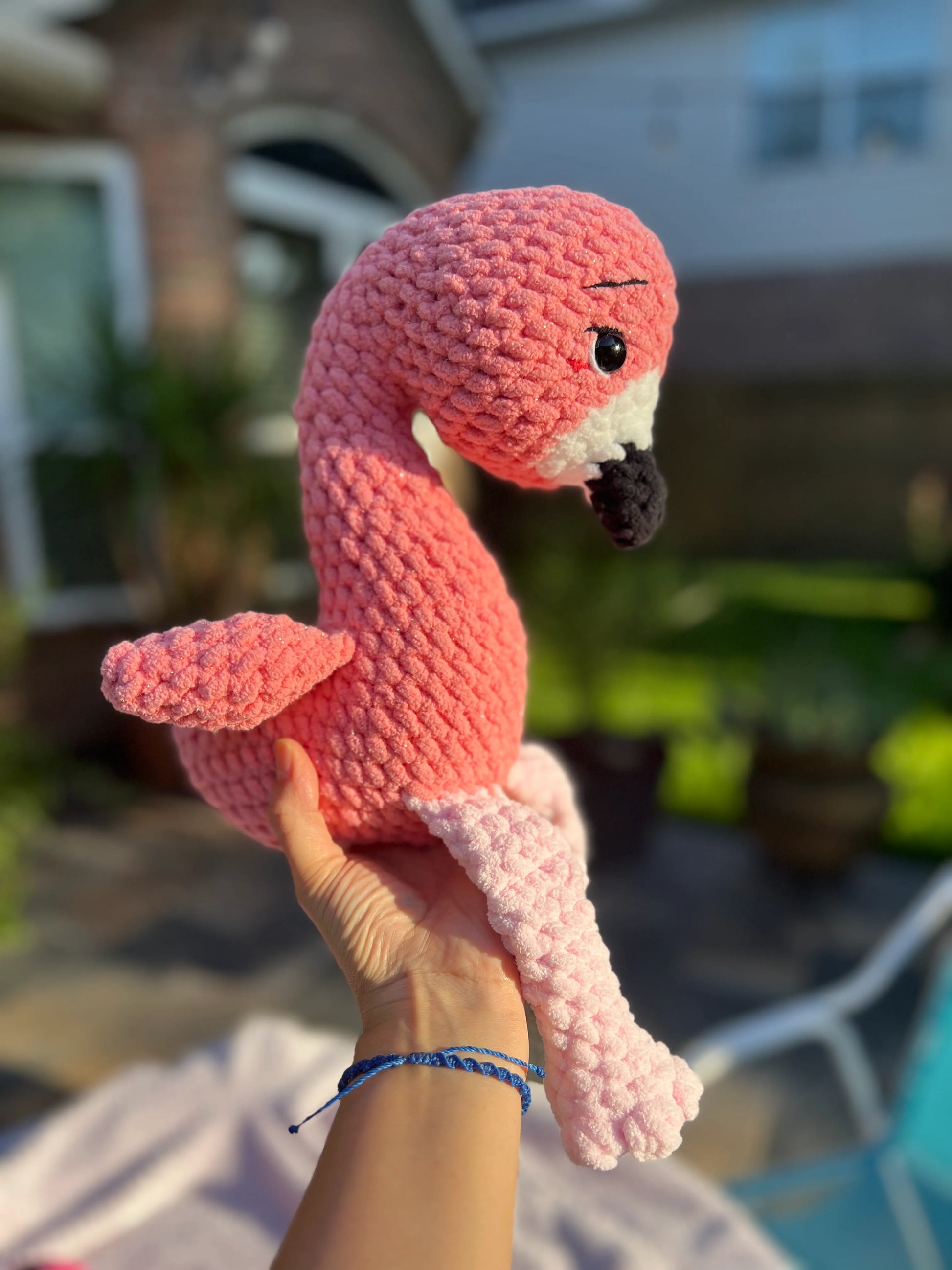 Side profile view of the pink flamingo plushie