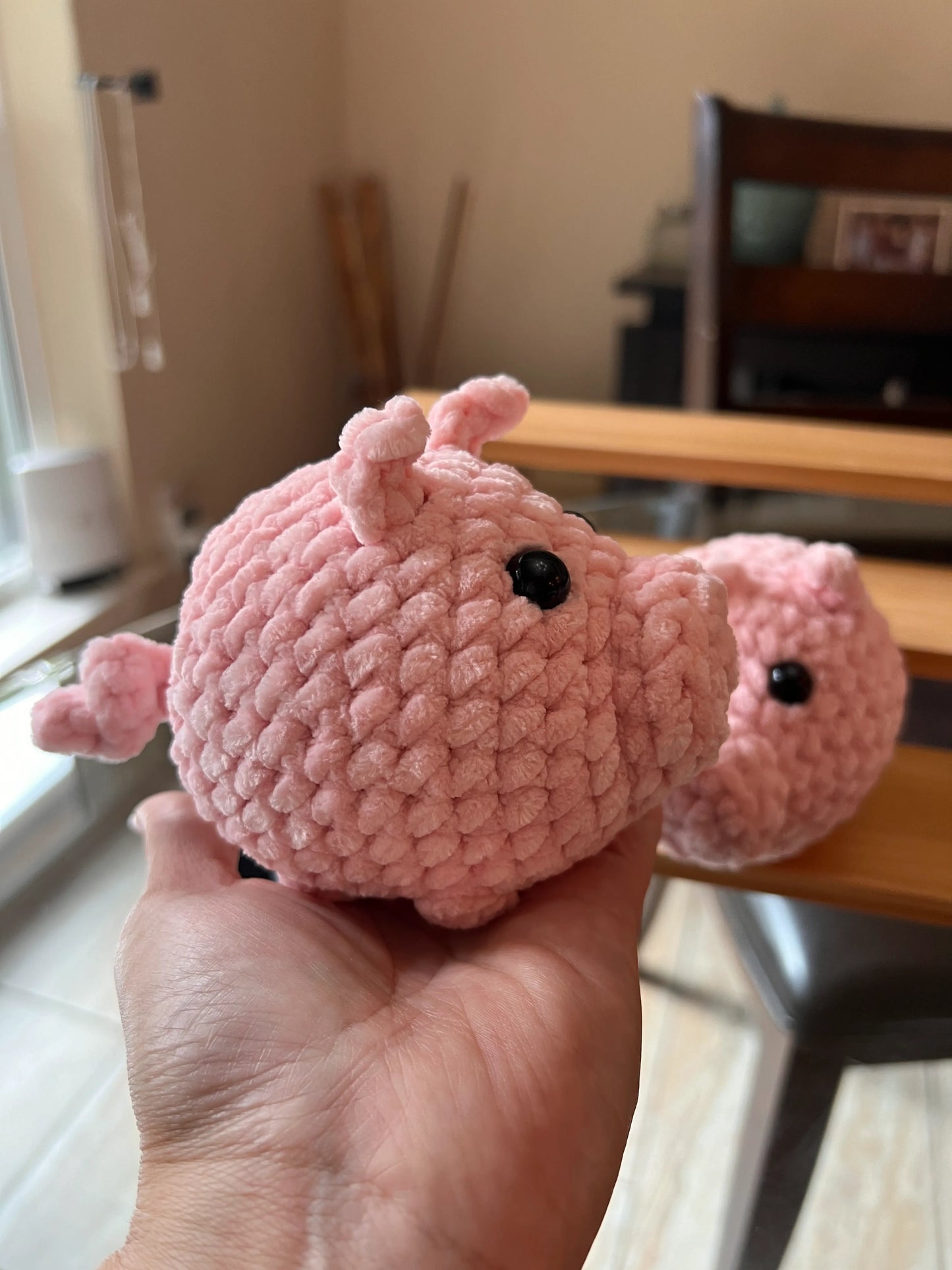 Side profile view of a pink pig plushie